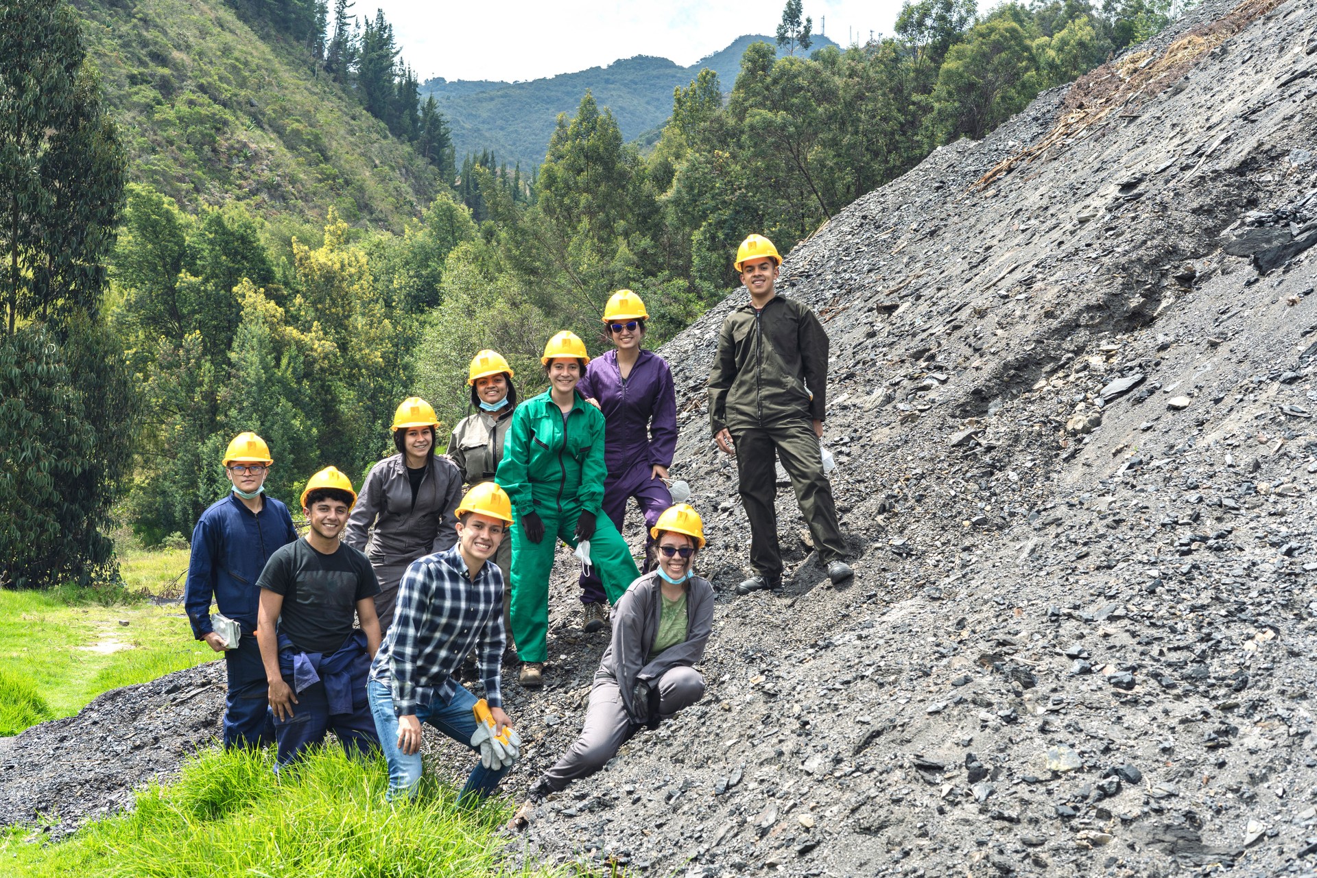 Group of students and miners looking at the camera while smiling.
