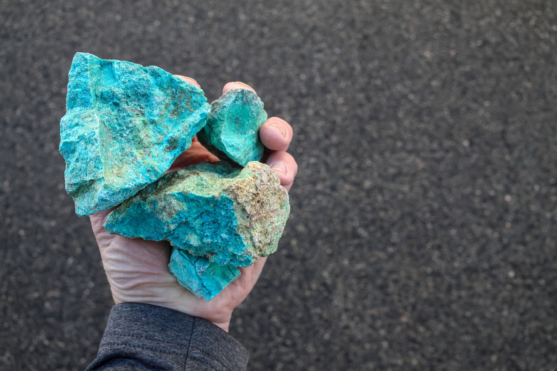 Blue green copper (Cu) oxide ore, held in hand. Mining.